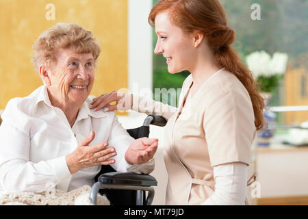 Smiling Woman talking to a friendly soignant dans la maison de soins infirmiers Banque D'Images