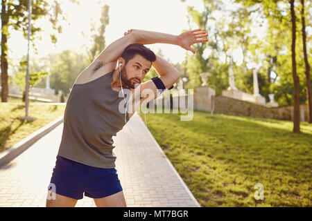 Young man doing stretching dans le parc. Banque D'Images