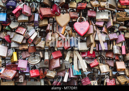 Une collection de serrures d'amour colorées attachées à une clôture, avec des noms et des messages gravés sur chaque serrure, symbolisant l'amour éternel et l'engagement, Banque D'Images