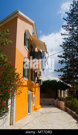 Chambre avec balcon, peint en jaune et crème solaire, dans une petite rue à Fiskardo sur l'île grecque Cephalonia Banque D'Images