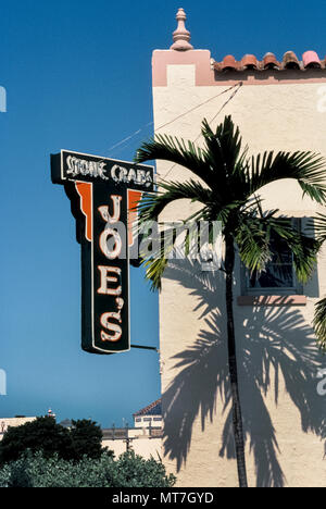 Un signe extérieur identifie Joe's Stone Crabes, un restaurant qui a été au service de son homonyme de succulents fruits de mer depuis les années 1920 à Miami Beach, Floride, USA. Quand Joseph Weiss a ouvert son premier restaurant sur la plage, l'océan baie était plein de crabes de pierre mais personne ne pensait qu'à manger le crustaeans à carapace dure jusqu'à ce que Joe certains cuits dans l'eau bouillante, fissurée, leurs coquilles et réfrigérés le goût sucré de la viande de crabe avant de servir. Maintenant considéré comme un mets délicat, pierre pinces de crabe sont récoltés de façon saisonnière de la Floride, et les eaux continuent d'être en vedette sur le menu de ce restaurant populaire. Banque D'Images