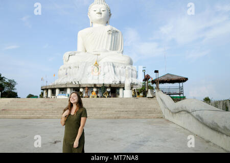 Jeune femme en robe kaki béton debout près de statue de Bouddha à Phuket. Banque D'Images