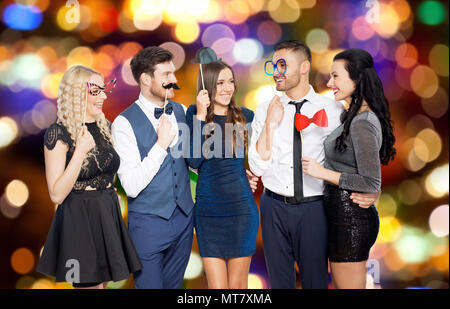 Happy friends with party props sur Lumières de fête Banque D'Images