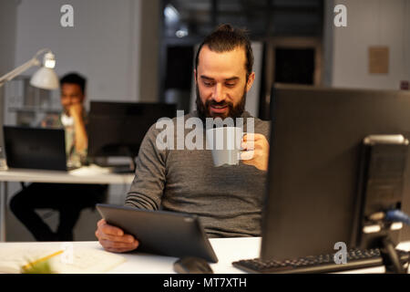 Man with tablet pc de boire du café au bureau Banque D'Images