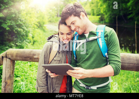 Couple heureux avec sacs à dos et tablet pc outdoors Banque D'Images