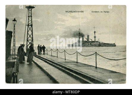 Carte postale photo historique allemand : jetée à l'entrée du port de Wilhelmshaven. Les femmes et les hommes sur le navire de guerre. la première guerre mondiale 1914-1918. Banque D'Images