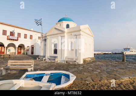 MYKONOS, Grèce - Mai 2018 : deux bateaux couchés sur le sable en face de l'église de saint Nicolas dans la vieille ville de Mykonos, Grèce. Objectif grand angle, tourné au lever du soleil. Banque D'Images