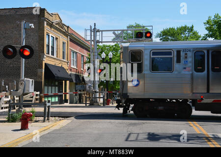 La ligne marron L-train traverse le quartier des affaires de l'Avenue de Rockwell au niveau de la rue dans le quartier des Jardins de Ravenswood. Banque D'Images