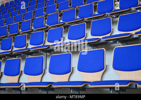 Des rangées de sièges vides du stade de fond bleu Banque D'Images