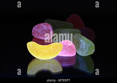 Beaucoup de gelée de fruits multicolores avec de la réverbération sur fond noir Banque D'Images