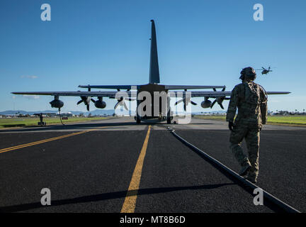 U.S. Air Force Tech. Le Sgt. Kade Bollinger suit le tuyau de ravitaillement retour à l'US Air Force MC-130J Commando II à la suite de l'avant des activités du point de ravitaillement en vol avec cinq HH-60 Blackhawks (du 6e Force d'assaut de l'aviation, 17 juillet 2017 à Mackay, Australie, champ. (U.S. Air Force photo : Capt Jessica Tait) Banque D'Images