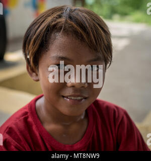 Un enfant de la communauté locale pose pour une photo comme les Marines américains affectés au 9e Bataillon d'appui du jouer un match de basket-ball avec un des soldats de l'Armée Philippine affectés à la 522ème bataillon de génie et de construction au cours d'un jeu de pick-up à l'école élémentaire en Calangitan Capas, Tarlac, Philippines, le 16 mai 2018. Balikatan 2018, dans sa 34e version, est un américain annuel-exercice d'entraînement militaire des Philippines a porté sur une grande variété de missions, y compris l'assistance humanitaire et les secours en cas de catastrophe, le contre-terrorisme et autres opérations militaires conjointes qui s'est tenue du 7 au 18 mai. (U Banque D'Images