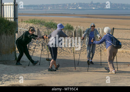 Marche nordique, activité physique favorisant la santé, une forme de mobilité assistée qui peut être appréciée à la fois par les non-athlètes comme activité physique favorisant la santé.Crosby, Merseyside.Météo Royaume-Uni.Juin 2018.Soleil, vents et nuages sur la côte tandis que les résidents actifs de la région s'exercent sur le sentier côtier.Quatre femmes, un groupe de marchettes de dame, l'activité est exécutée avec des bâtons de marche spécialement conçus semblable à Banque D'Images