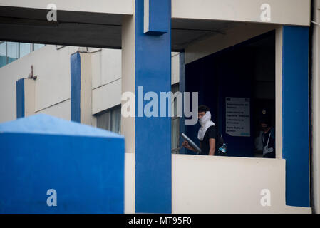 28 mai 2018, le Nicaragua, Managua : deux manifestants masqués avec une arme improvisée dans leurs mains à pied par un couloir de l'Université de l'ingénierie. Pendant les protestations entourant la prise de l'université, il y a eu des affrontements entre les étudiants, les forces de sécurité et un groupe non identifié. Les étudiants ont annoncé la lutte pour l'autonomie du système d'éducation et contre l'initiative gouvernementale leadership étudiant. Le Nicaragua a été voir des manifestations contre le Président Ortega depuis la mi-avril. Photo : Carlos Herrera/dpa Banque D'Images