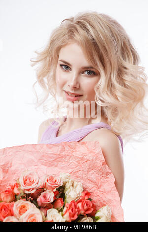 Portrait de femme avec de magnifiques cheveux bouclés blondy make-up parfait. Holding bouquet Banque D'Images