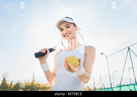 Joueur de tennis femme montrant la balle Banque D'Images