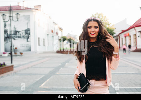 Cheerful pretty girl avec des bijoux sur la tête en dentelle top et costume avec un sac à main. Banque D'Images