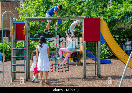 Les enfants de grimper sur un mur d'escalade et net dans l'aire de jeux pour enfants dans un baccalauréat Acre à Windsor en tant que parent, les montres et les surveille. Banque D'Images