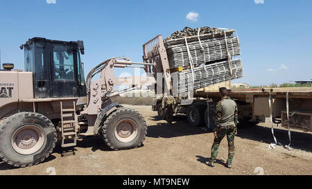 Les membres de la Force aérienne irakienne et l'armée américaine 574th Combat Support Command travaillent ensemble pour charger les palettes récupérées 463L sur un camion de l'Armée américaine à Al Muthana Air Base, l'Iraq, le 16 avril 2017. L'initiative de récupération de palettes, dirigée par les portiers aux Centre de soutien diplomatique à Bagdad, Iraq, impliqués au recouvrement de plus de 1 500 palettes d'aéronefs et de 1 600 filets de cargaison, qui ont été utilisés pour les ventes de matériel militaire à l'étranger Marchandises destinées à l'armée iraquienne pour lutter contre ISIS à Mossoul. Banque D'Images