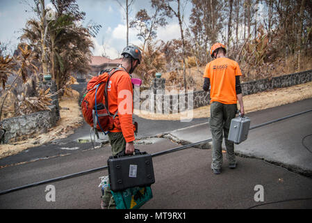 Pāhoa, New York, 19 mai 2018 - U.S. Geological Survey (USGS) Allen bénévoles Lerner (à gauche) et l'USGS Chercheur Christoph Kern (à droite) se préparer à utiliser le dioxyde de soufre (SO2) des capteurs pour surveiller et tester la qualité de l'air après le Kīlauea éruption volcanique. La zone résidentielle de Leilani Estates a été évacué en raison de la forte concentration de SO2 de l'émettant des fissures dans la terre que dans la lave déversée subdivisions. À la demande de l'état, le personnel de la FEMA sont sur le terrain pour soutenir les responsables locaux avec des mesures de protection d'urgence, l'enlèvement des débris, et la réparation, re Banque D'Images