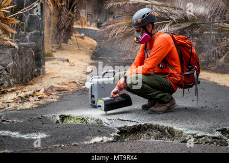 Pāhoa, New York, 19 mai 2018 - U.S. Geological Survey (USGS) Allen bénévoles Lerner utilise un dioxyde de soufre (SO2) capteur pour tester la qualité de l'air après le Kīlauea éruption volcanique. La zone résidentielle de Leilani Estates a été évacué en raison de la forte concentration de SO2 de l'émettant des fissures dans la terre que dans la lave déversée subdivisions. À la demande de l'état, le personnel de la FEMA sont sur le terrain pour soutenir les responsables locaux avec des mesures de protection d'urgence, l'enlèvement des débris, et la réparation, le remplacement, ou la restauration des installations appartenant à l'état endommagé. Photo : Banque D'Images