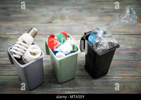 Concept de l'écologie, beaucoup d'objets recyclables dans des conteneurs sur le fond en bois. Banque D'Images