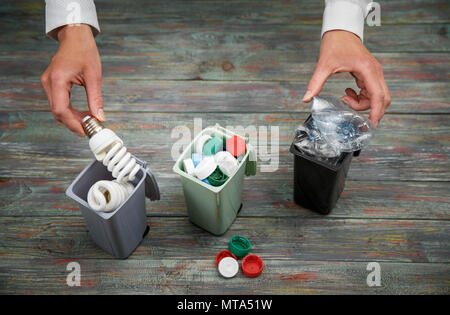 Concept de l'écologie, beaucoup d'objets recyclables dans des conteneurs sur le fond en bois. Banque D'Images