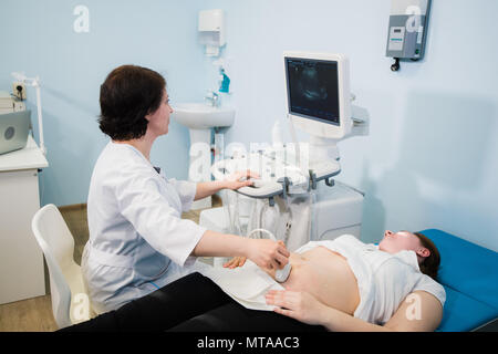 Femme enceinte faire échographie dans la clinique prénatale, mère inquiète de la santé de son futur bébé, heureux temps de la grossesse Banque D'Images