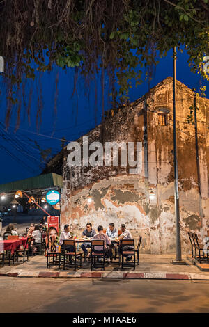 Les gens assis à table dans la rue bar, Thakek, Laos Banque D'Images