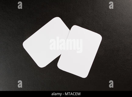 Cartes d'affaires en blanc avec coins arrondis sur un fond noir en cuir Banque D'Images