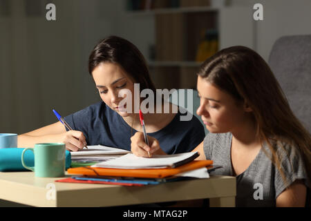 Deux élèves studieux étudiant sérieusement à des heures tardives dans la nuit à la maison Banque D'Images