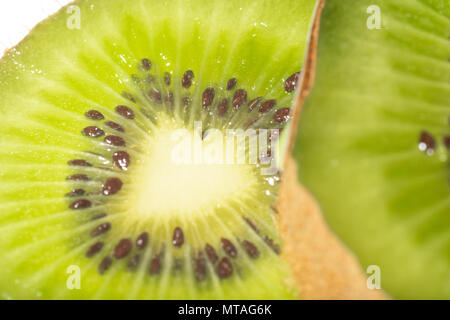 Tranches de kiwi macro photographie placée sur un fond blanc. Banque D'Images
