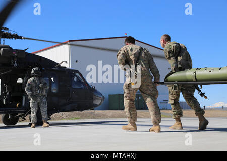 Des soldats américains dans le cours de Dirigeants CBRNE Prendre un litre d'un UH-60 Blackhawk hélicoptère pendant charge à chaud de la formation au Centre de formation de Yakima, Washington, le 21 avril 2017. Le cours de Dirigeants CBRNE est conçu pour créer des leaders capables de s'adapter la lutte contre les menaces chimiques, biologiques, radiologiques, nucléaires, et les dangers à la fois permissif et non permissif l'environnement partout dans le monde. Banque D'Images