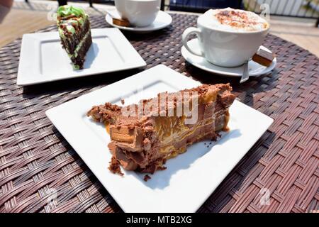 Gâteau chocolat caramel Gooey partie avec du cappuccino Banque D'Images