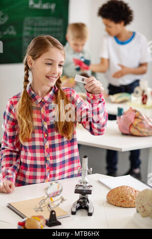 Plaisir positif girl holding a microscope Banque D'Images