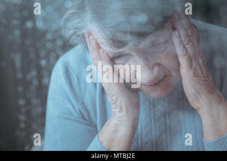 Senior woman having maux, holding head avec ses mains Banque D'Images