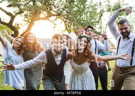 Mariée, marié, vous posant pour la photo de réception de mariage à l'extérieur dans la cour. Banque D'Images