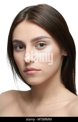 Close up of a Girl avec lumière jour composent looking at camera. modèle avoir beau visage avec beau sourire, lèvres charnues, de grands yeux, des dents blanches. Des cheveux bruns foncés, a ouvert les épaules. Studio blanc arrière-plan. Banque D'Images