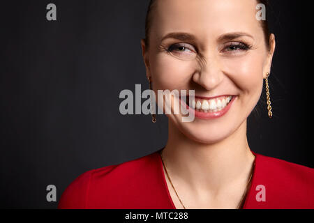 Close-up of young attractive woman avec sourire blanc sur fond noir. Banque D'Images