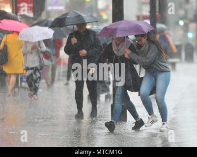 Les personnes prises dans la pluie sur Oxford Street, au centre de Londres comme les prévisionnistes ont mis en garde contre le risque d'inondations, plus de perturbation de voyage et des coupures de courant avec des orages mis à gronder. Banque D'Images