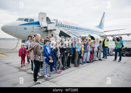 30 mai 2018, l'Allemagne, Hanovre : Enfants et jeunes mères debout en face d'un avion à l'aéroport de Hanovre. Depuis 28 ans, une initiative de l'Eglise luthérienne évangélique de Hanovre a été endommagée par le rayonnement de vol les enfants de la région de Tchernobyl à Hanovre pour récupérer. Les enfants restent avec les familles pendant quatre semaines. Photo : afp/Spata Ole : dpa Crédit photo alliance/Alamy Live News Banque D'Images