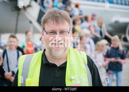 30 mai 2018, l'Allemagne, Hanovre : Lars-Torsten Nolte du groupe de travail 'Hilfe für Tschernobyl-Kinder' (lit. 'Aide pour les enfants de Tchernobyl') debout devant des enfants et des jeunes mères qui sont debout sur les escaliers de l'avion à l'aéroport de Hanovre. Depuis 28 ans, une initiative de l'Eglise luthérienne évangélique de Hanovre a été endommagée par le rayonnement de vol les enfants de la région de Tchernobyl à Hanovre pour récupérer. Les enfants restent avec les familles pendant quatre semaines. Photo : afp/Spata Ole : dpa Crédit photo alliance/Alamy Live News Banque D'Images