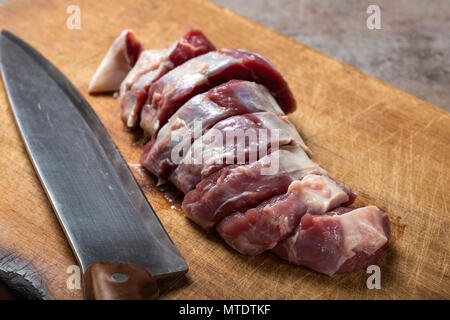 Tranches de viande de boeuf sur une planche à découper en bois avec un couteau de cuisine Banque D'Images