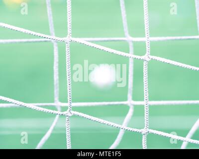 Le ballon de soccer sur l'herbe verte vue par un carré vert gate net. Ballon de football en arrière-plan, sport Objectif Banque D'Images