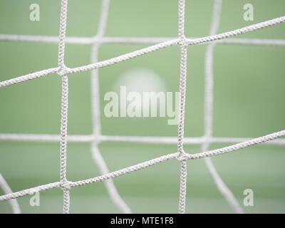 Le ballon de soccer sur l'herbe verte vue par un carré vert gate net. Ballon de football en arrière-plan, sport Objectif Banque D'Images