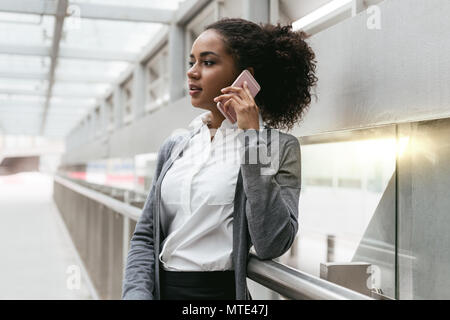 Young Woman talking on cellphone at airport Banque D'Images