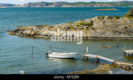 Petit bateau amarré par une jetée dans l'archipel rocheux sur une journée ensoleillée. Tjuvkil Emplacement extérieur Kungalv, Suède. Banque D'Images