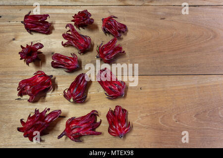 Roselle (Hibiscus sabdariffa) calices de couleur magenta (sépales) cadre sur fond de table en bois, télévision lay Banque D'Images