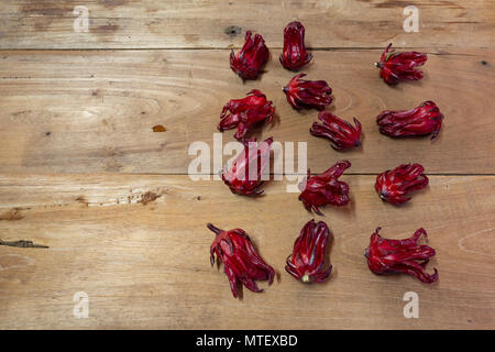 Roselle (Hibiscus sabdariffa) calices de couleur magenta (sépales) cadre sur fond de table en bois, télévision lay Banque D'Images