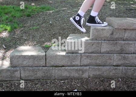 Adolescente à monter et descendre les escaliers portant des chaussettes blanches et une paire de baskets converse noir haut-tops. Banque D'Images